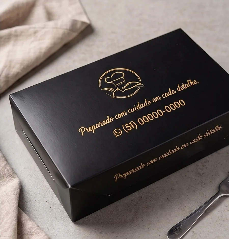 Box preta com logo e mensagem Preparado com cuidado em cada detalhe impressos em dourado, com WhatsApp na tampa